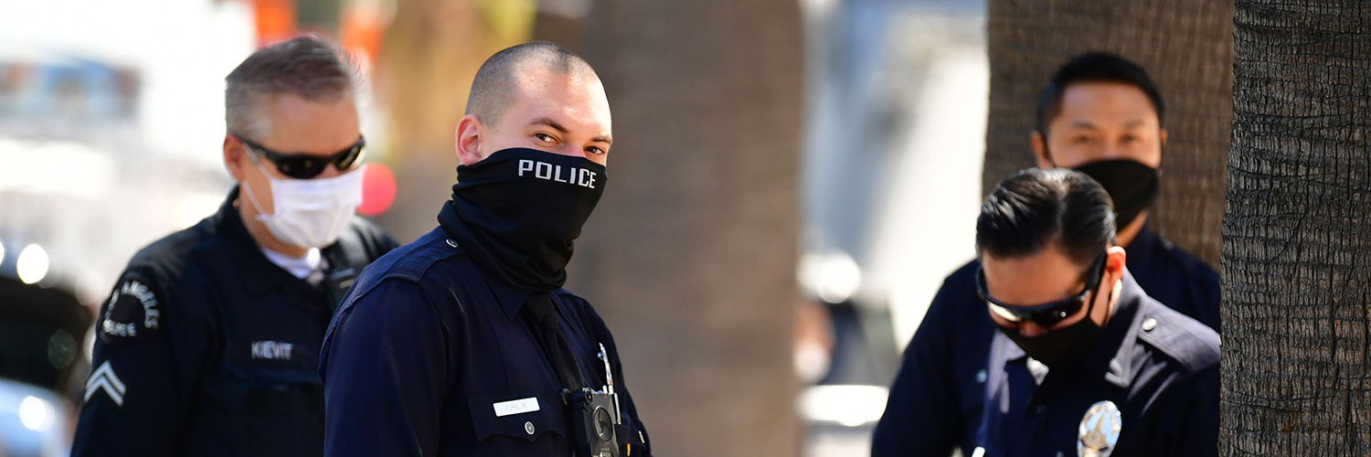 Los Angeles Police Department (LAPD) officers wear facial covering while monitoring an "Open California" rally in downtown Los Angeles, on April 22, 2020. 