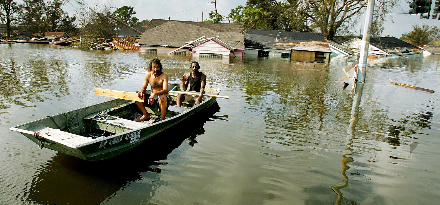 Two men paddle in high water in the Ninth Ward after Hurricane Katrina devastated the area August 31, 2005 in New Orleans, Louisiana.