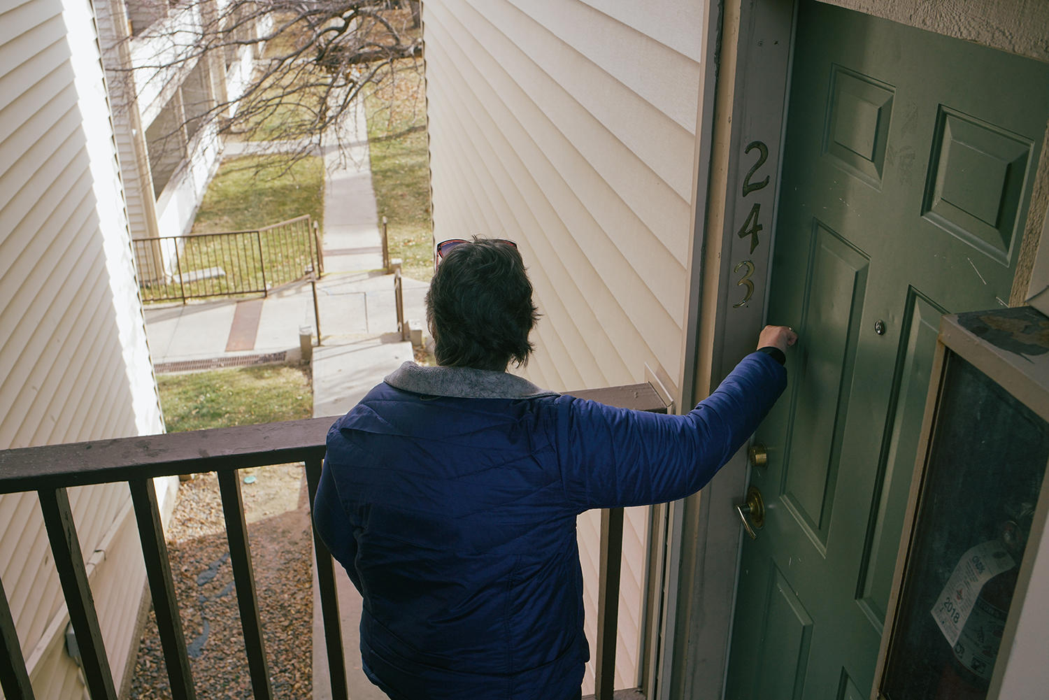 Lisa Bryant, a clinical case manager with Mental Health Center of Denver, knocks on the apartment door of a program participant.