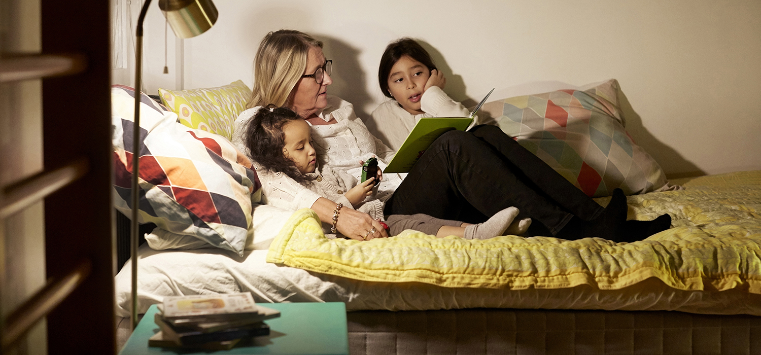 Woman reading to two young girls. 