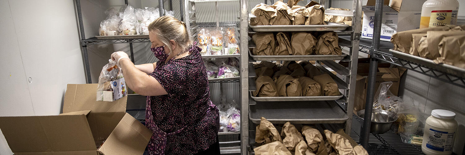 Deborah Jendrasko prepares the free bag lunches for students at Deering High School on Friday