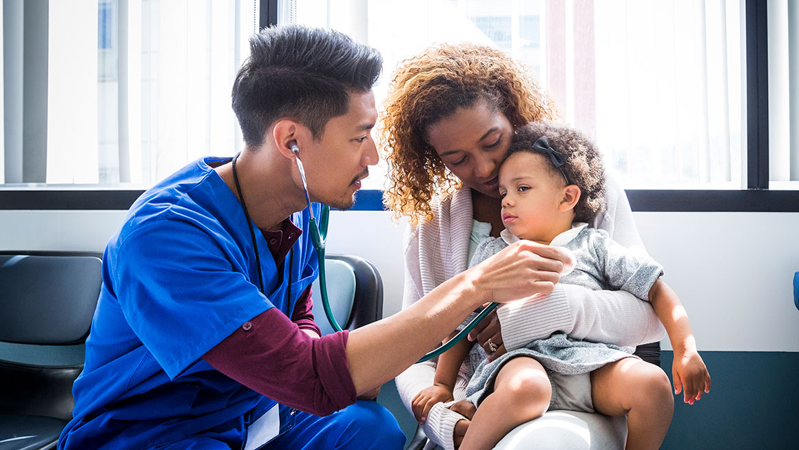 A health care professional examining a child. 