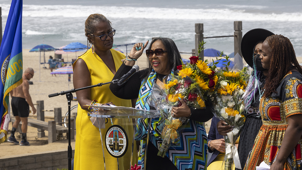 Patricia Bruce-Carter speaks as flowers are presented to some members of the Bruce family at a ceremony to return ownership of Bruce's Beach to the descendants of a Black family who had the land stripped from them nearly a century ago on July 20, 2022 in Manhattan Beach, California