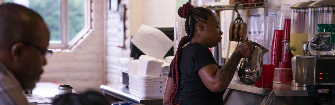 Server Donita Jackson fills water cups at the Florida Avenue Grill