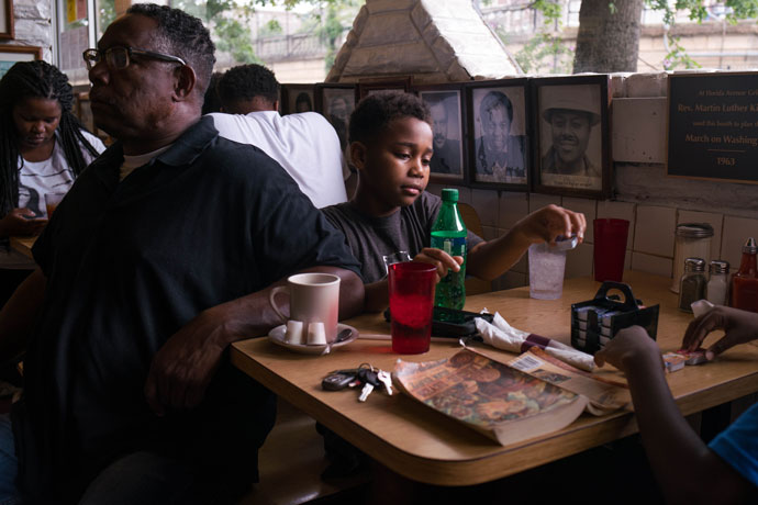 Desmond Gonzalez, plays with jam packets ahead of his family's breakfast at Florida Avenue Grill