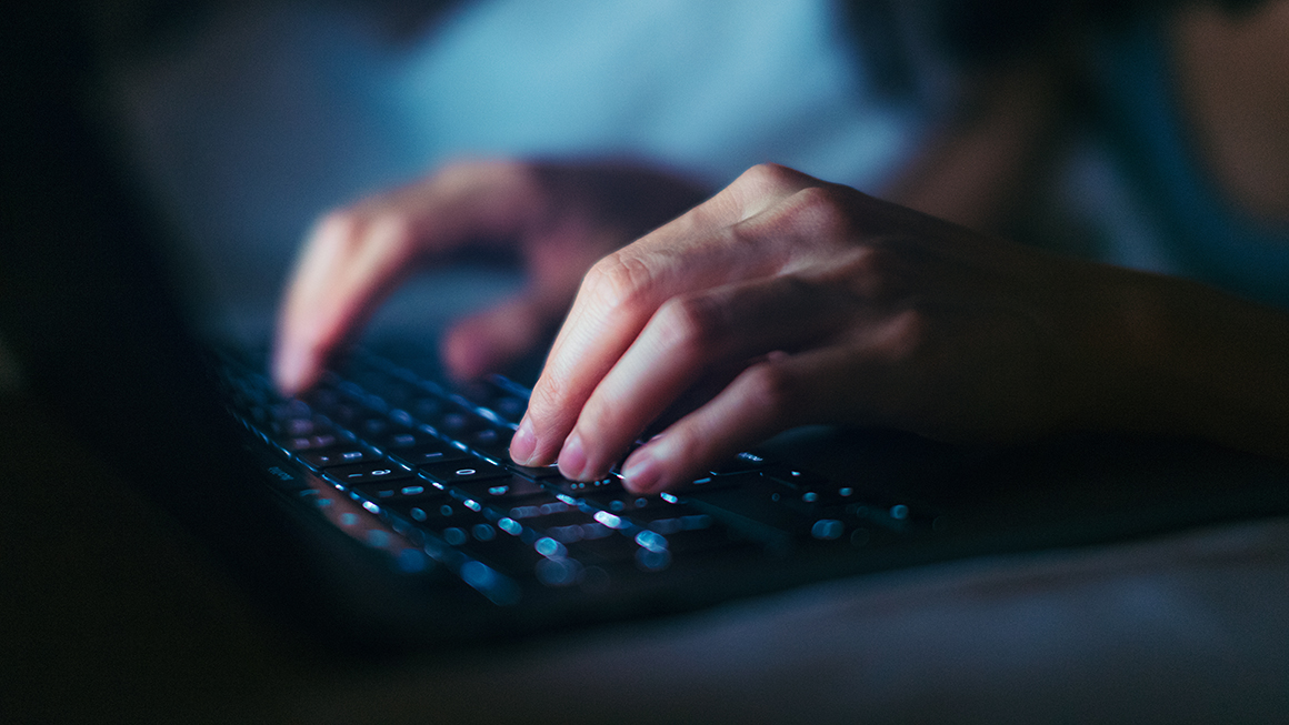 A close up of someone typing on a keyboard.
