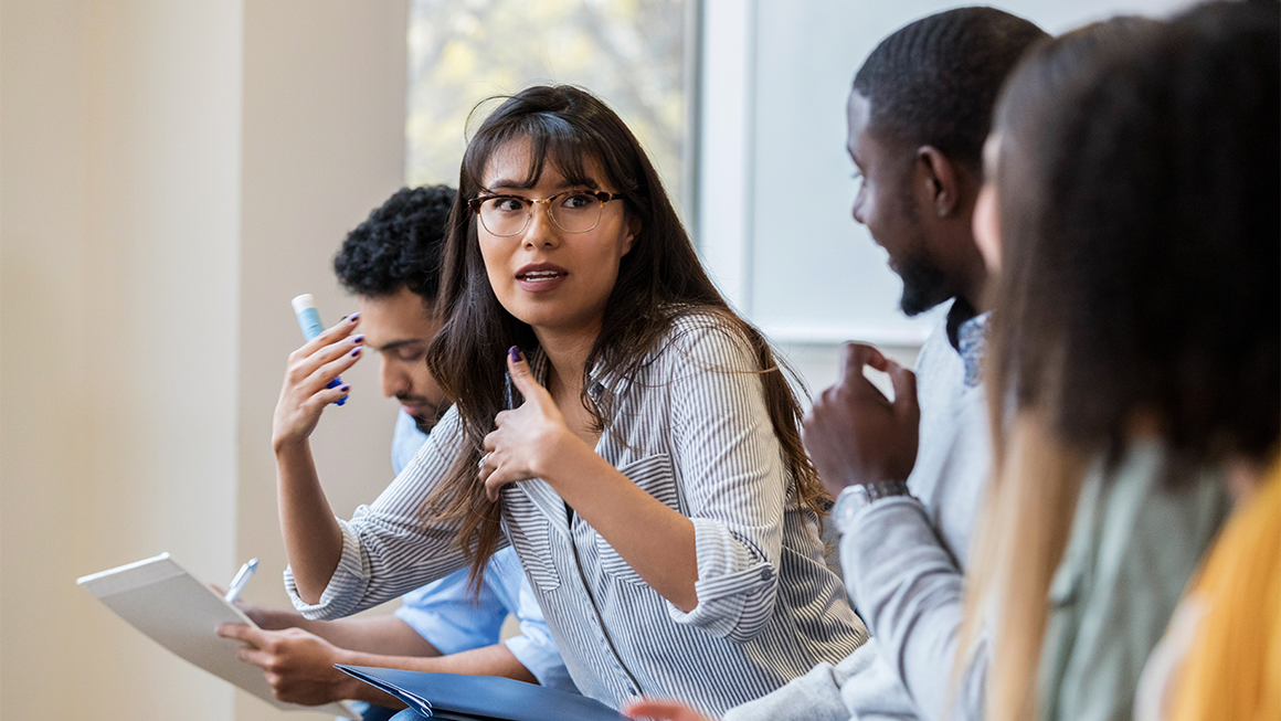 Young female creative professional talks withe colleague