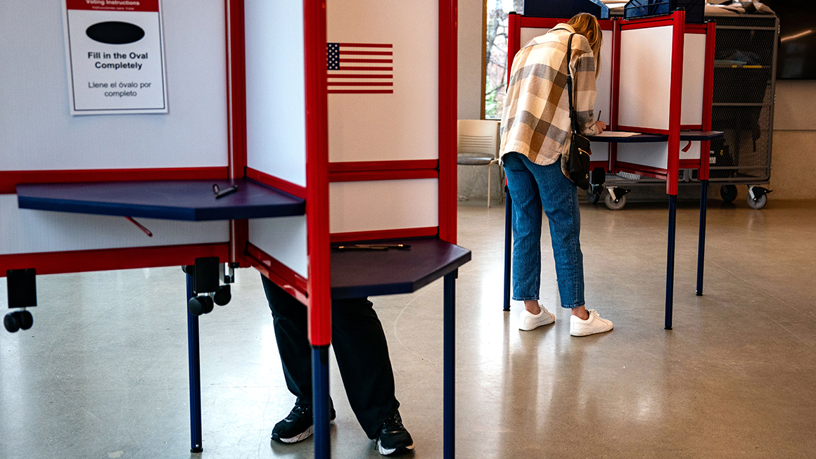 Voters cast their ballots at a polling location at the Lubber Run Community Center