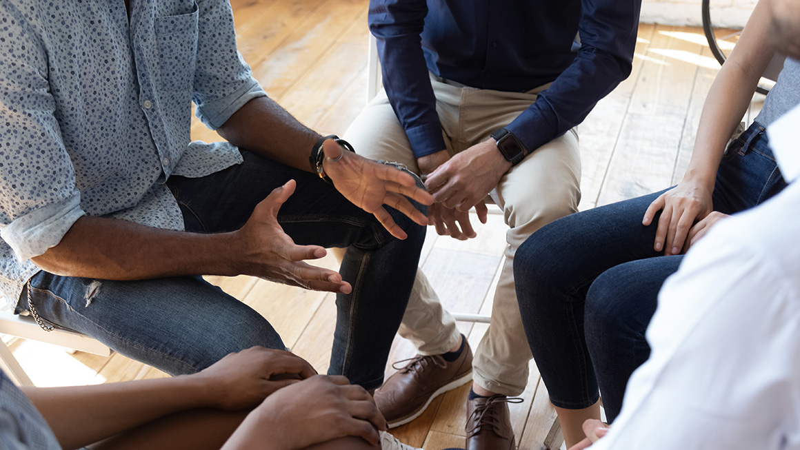 photo of people and counselor speak at group counseling therapy session