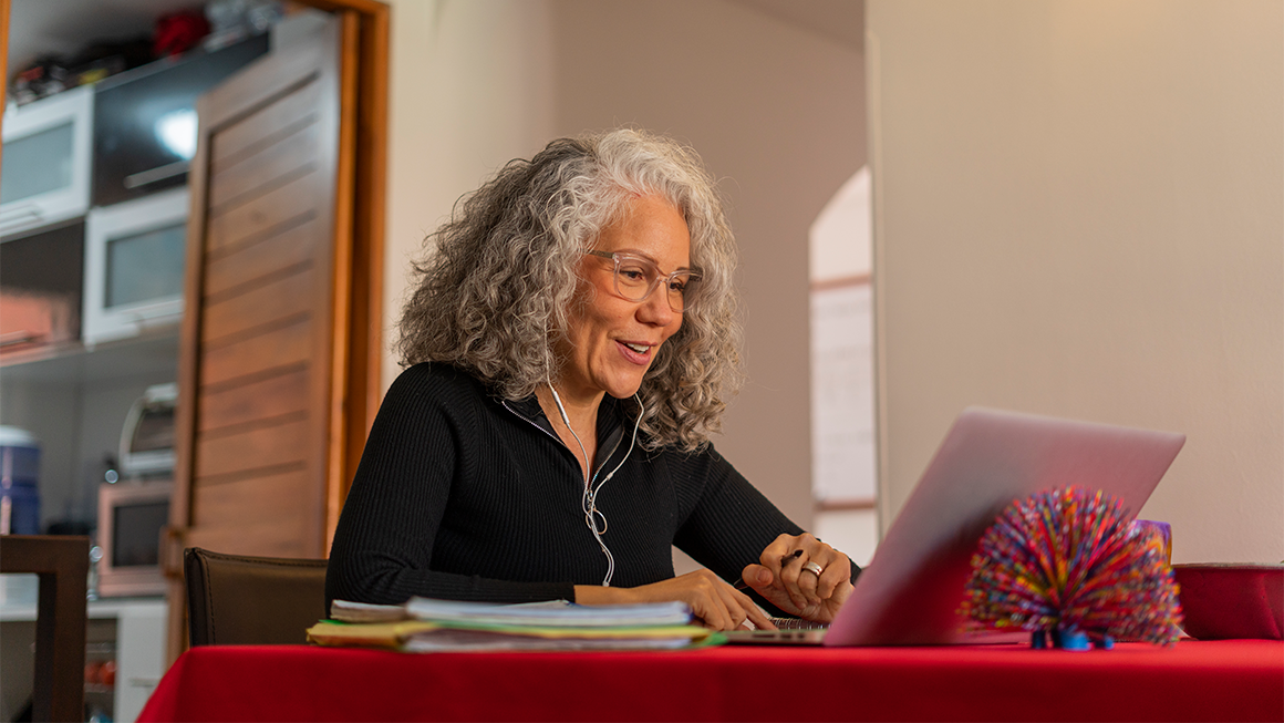An older woman working on her laptop.