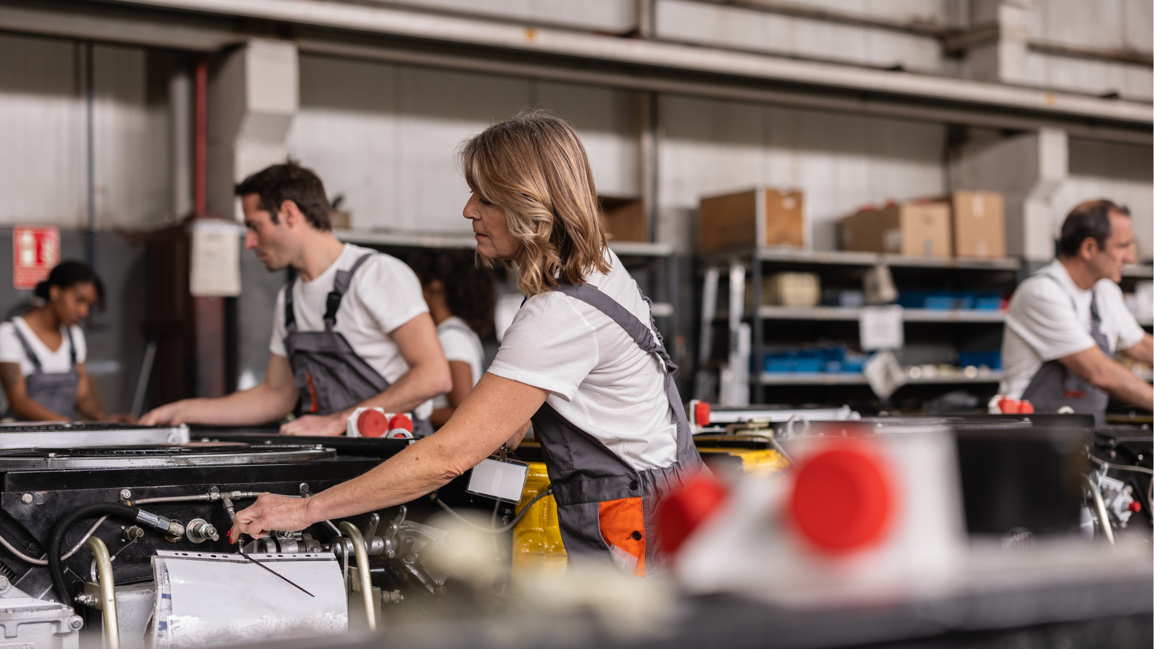 Several people work on machines in a factory