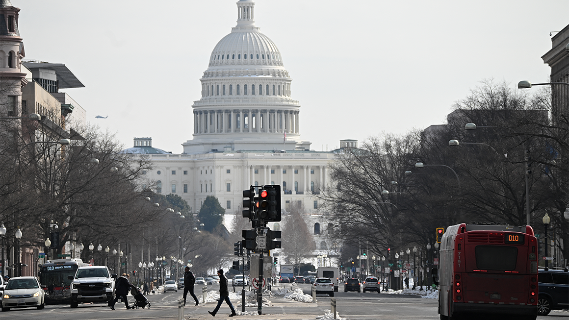 Photo of the Capitol building and a busy street on a gray winter day.