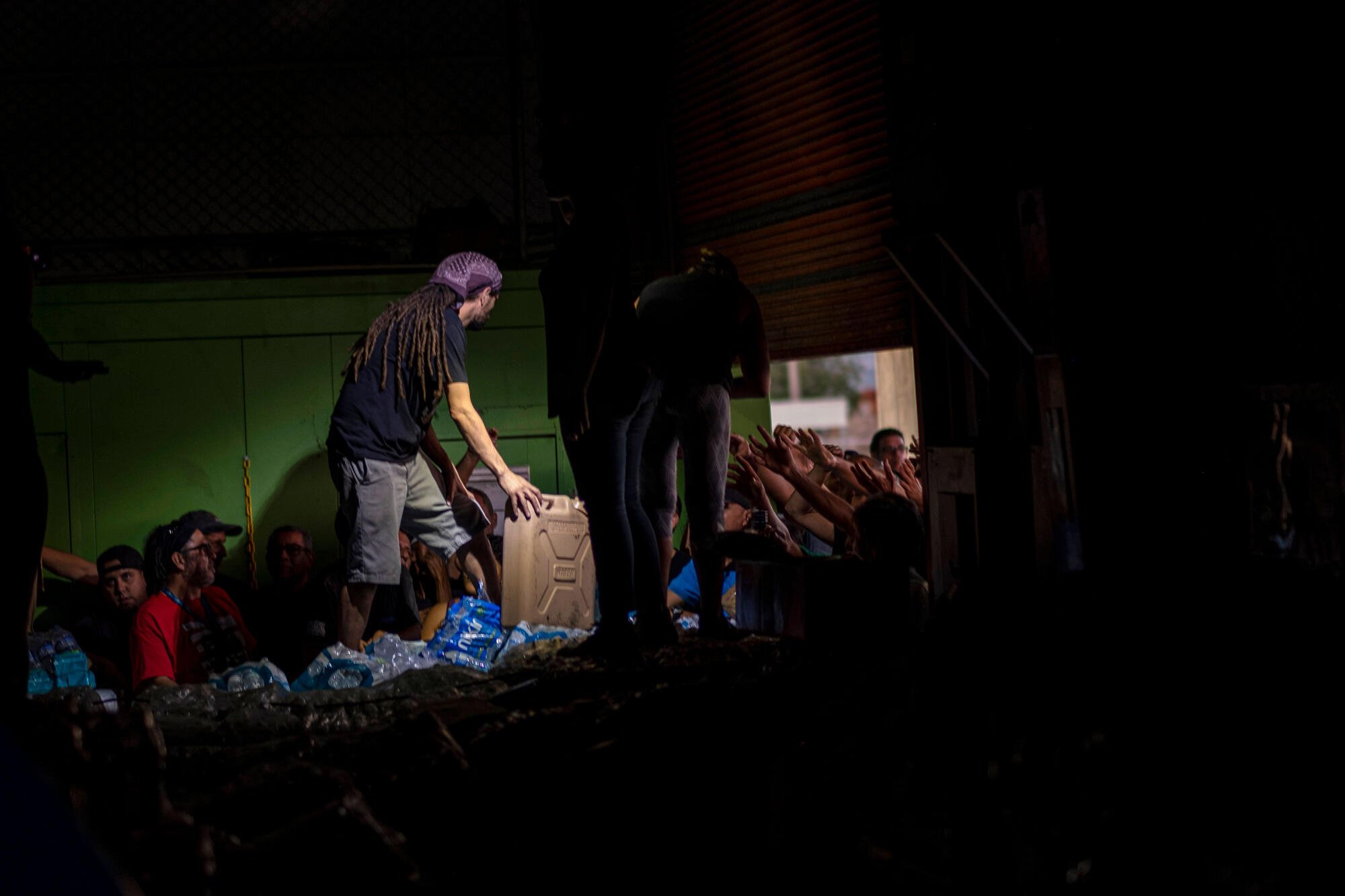 photo of people reaching out to receive supplies 