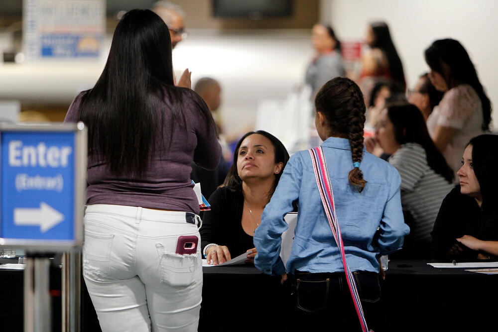 photo of people getting information at the Reception Center for Puerto Rican refugees set up at the Orlando International Airport in Orlando, Florida
