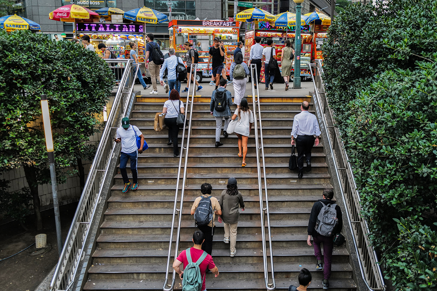 Pedestrians climbing stairs to an outdoor food court in New York City.