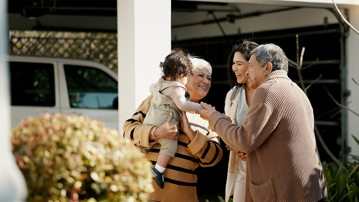 Photo of a multigenerational group of family members reuniting in a yard. 