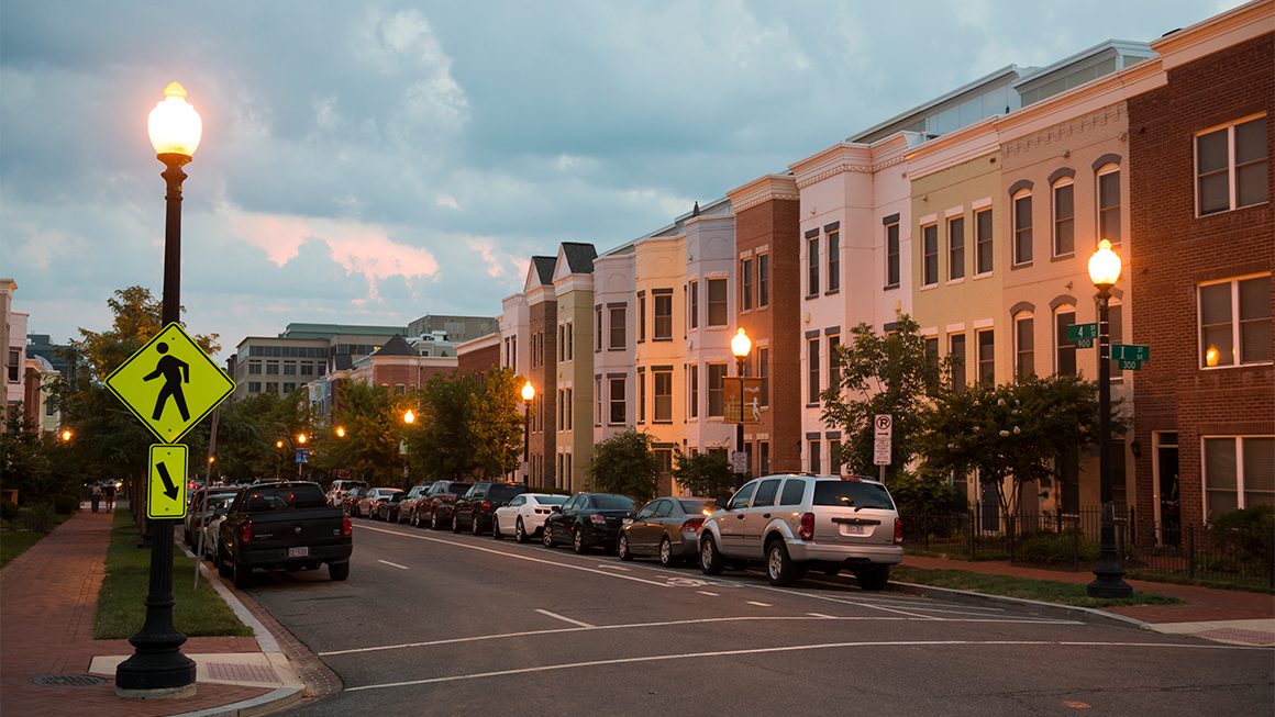 Quiet residential street with modern townhomes at dusk.