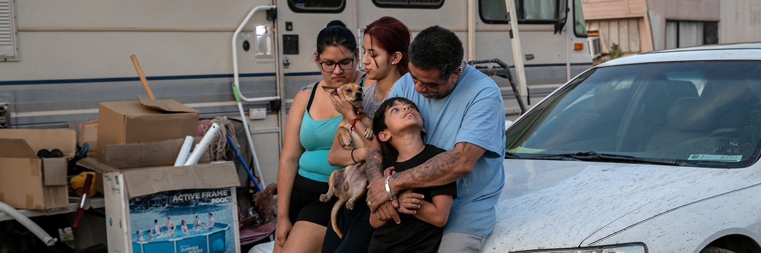 A family sits outside their RV