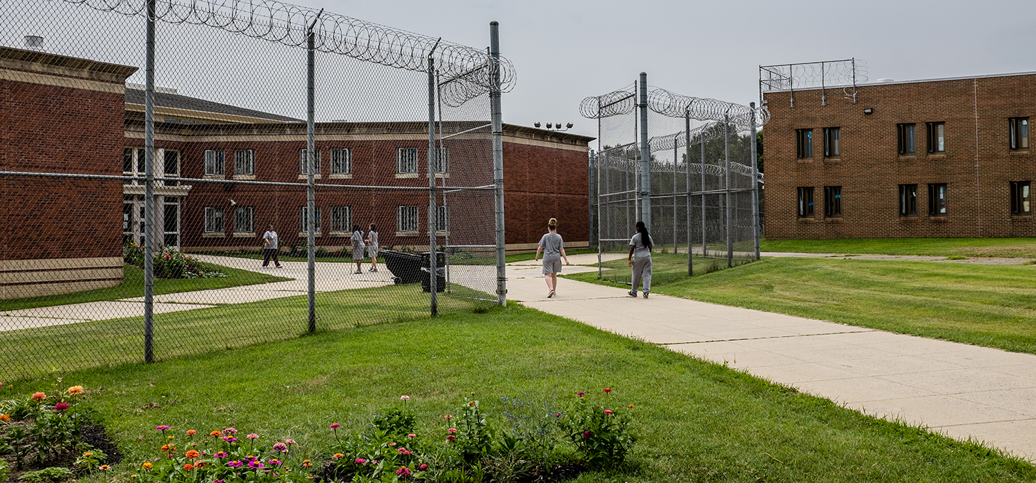 Incarcerated people walk outside a correctional facility