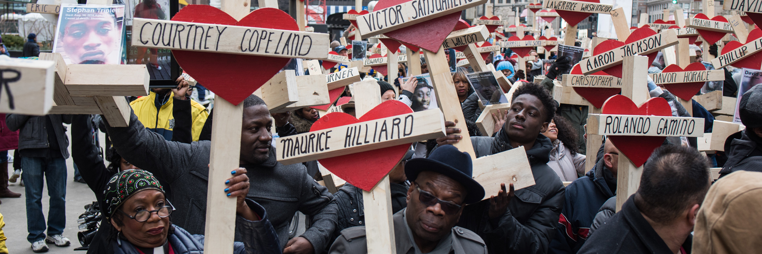 People raise over 750 wooden crosses which are dedicated to lives lost in 2016 in Chicago during a peace march on December 31, 2016.