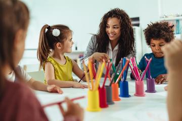 Teacher and children being creative with colorful pencils