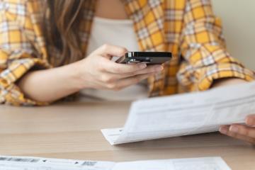 Close-up people using smartphone apps pay bills via online payment at home.