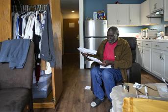 Army veteran Reggie Austin sits in his apartment looking at some paperwork at the newly-opened Tunnel to Towers Veterans Village