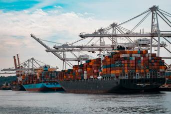 Cargo ships docked at a pier during day