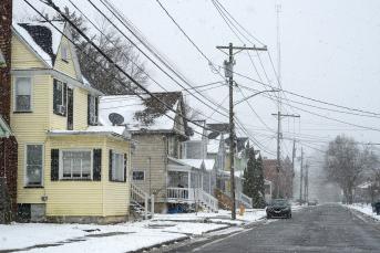 Photo of a street lined with colorful houses on a snowy day.