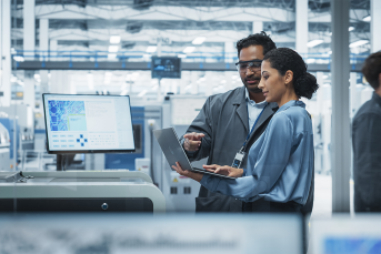 photo of Male Industrial Engineer And Female Supervisor Using Laptop And Talking At An Electronics Factory