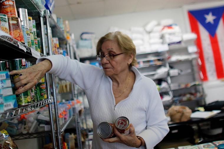 rma Ramos, 71, organises donated canned food into shelves at the Latino Leadership headquarters in Orlando, Florida on December 1, 2017. 