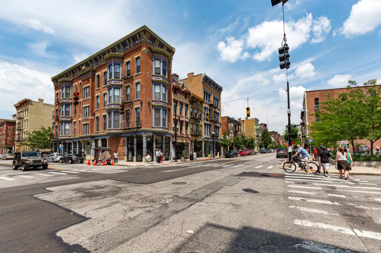 photo of  pedestrians walking around the intersection of 12th and Vine Streets in the rapidly gentrifying Over-the-Rhine district on a summer day