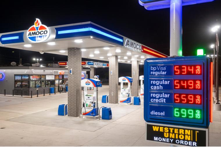 Amoco gas station with illuminated fuel price sign at night.