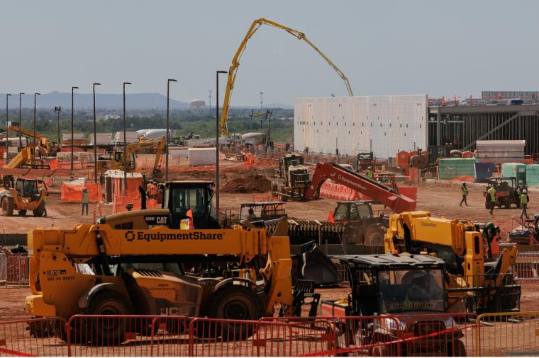 Construction site with heavy equipment and workers.