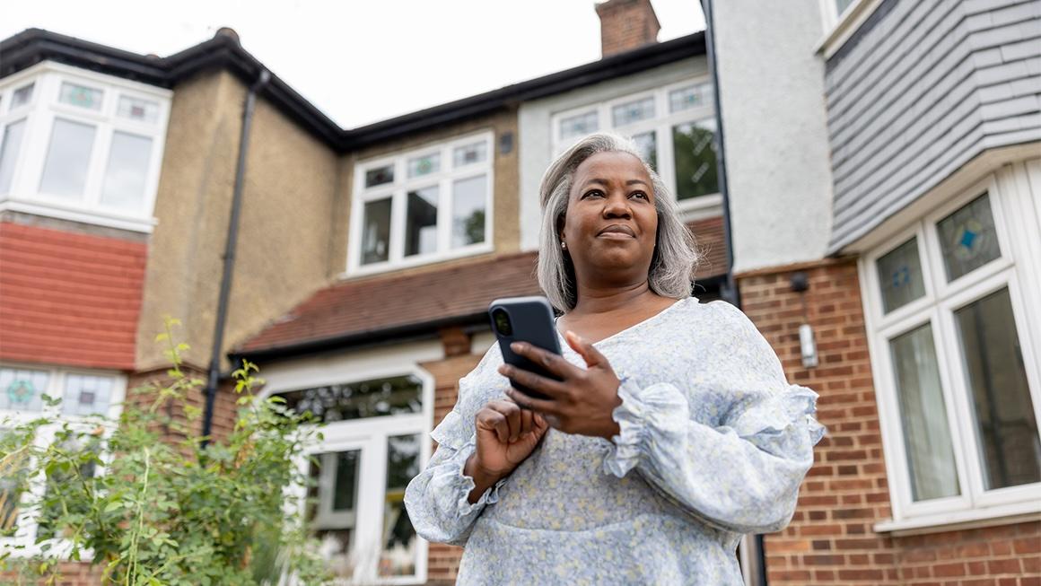 photo of woman standing in front of house