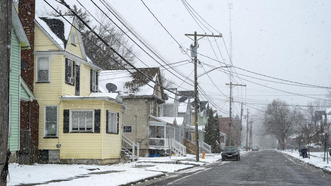 Photo of a street lined with colorful houses on a snowy day.