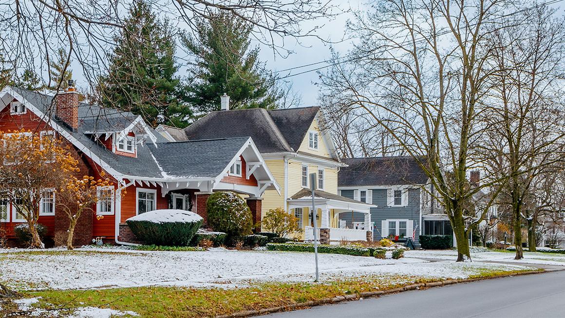Three suburban houses on a snow-dusted street
