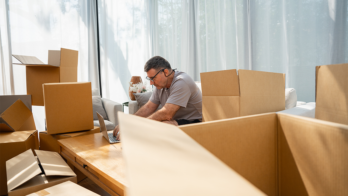 photo of a man, during a transfer, packing and using his laptop