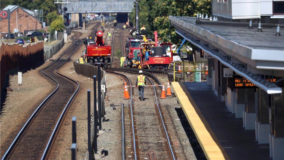 train tracks with workers in the daytime