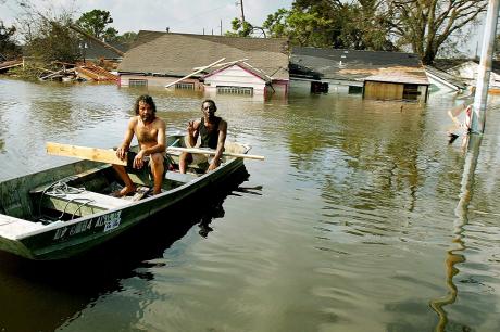Two men paddle in high water in the Ninth Ward after Hurricane Katrina devastated the area August 31, 2005 in New Orleans, Louisiana.