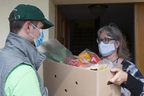 Woman accepts a box of produce