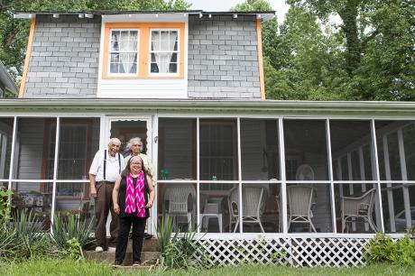 Family stands in front of their home