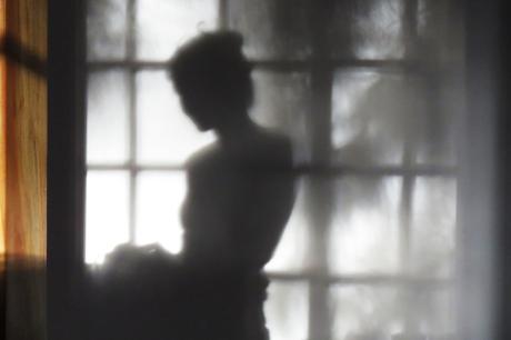 Woman stands in front of window