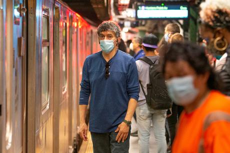 People wearing mask wait on a crowded subway platform on May 30, 2020 in New York City.