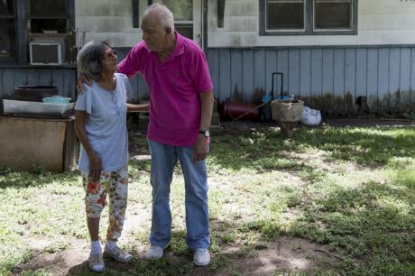 Janie and Jessie Peña stand for a portrait in front of their home, which was destroyed in Hurricane Harvey, in Wharton, Texas on July 1, 2018.