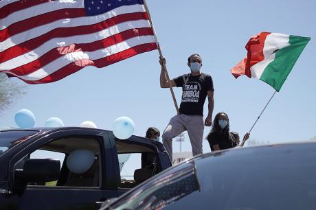 Man waves flag during rally for immigrant workers and families