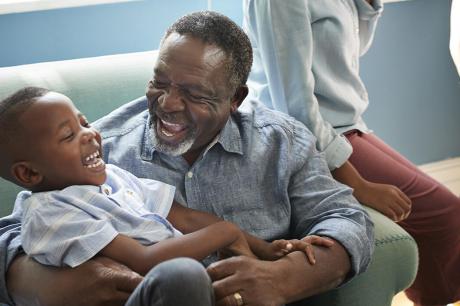 Happy elderly man playing with grandson