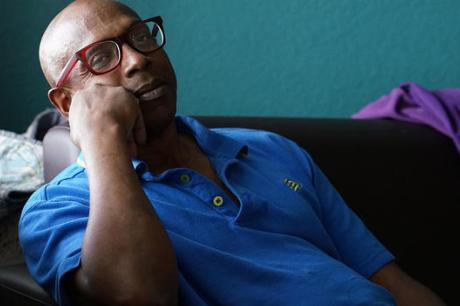 Man sitting in living room resting head on hand
