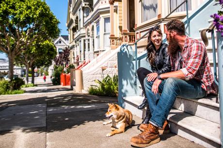 Couple with their dog on their front steps. 