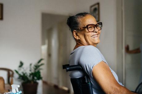 A woman of color in a wheelchair smiling